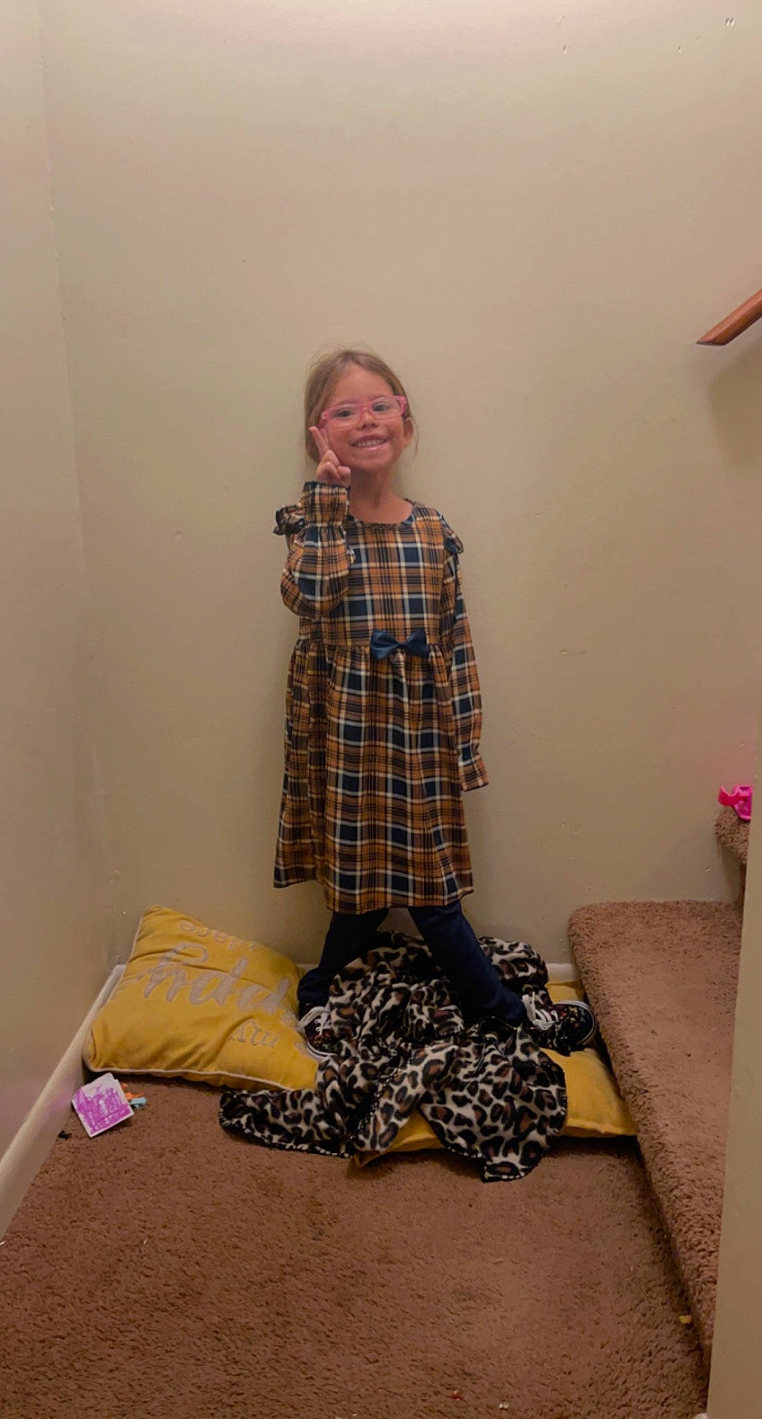 Addilyn is registered to the contest to win money with this photo: bag, comfort, fashion_design, floor, flooring, hardwood, human_leg, joy, knee, linens, luggage_and_bags, pattern, person, plaid, room, shoulder, sitting, sleeve, smile, tartan