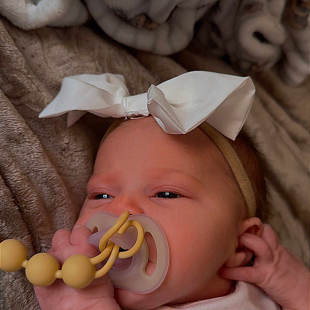 Gracelyn joined the competition — help win amazing prizes! baby, beads, blanket, bow, close_up, clothing, comfort, cute, hand, headband, indoors, infant, newborn, pacifier, peaceful, portrait, resting, skin, sleepy, soft_toys