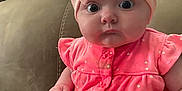 Jazlynn joined the competition — help win amazing prizes! baby, infant, pink_bow, headband, onesie, unicorn_patch, couch, seated, wide_eyes, cute, child, indoors, portrait, clothing, soft_fabric, expression, hand, face, small_person, adorable