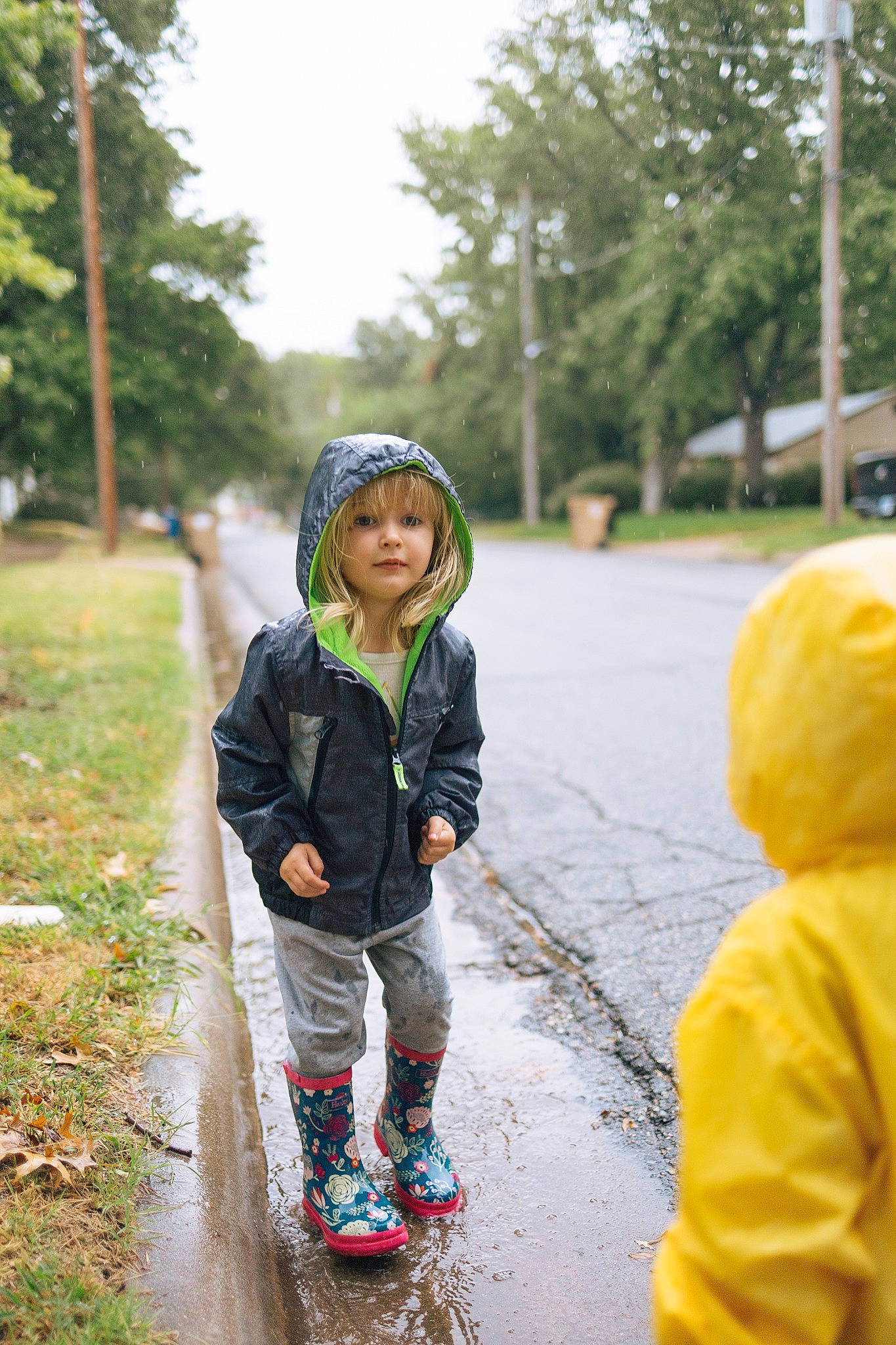 Josephine is registered to the contest to win money with this photo: asphalt, boot, child, fun, grass, happy, hat, headgear, headwear, jacket, leaf, leisure, people_in_nature, person, plant, recreation, sky, sneakers, spring, toddler