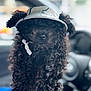 Diesel joined the competition — help win amazing prizes! dog, curly_fur, black_dog, pet, visor_hat, car_interior, close_up, portrait, animal, cute, furry, canine, indoor, seat, steering_wheel, blurry_background, adorable, nose, headwear, companion