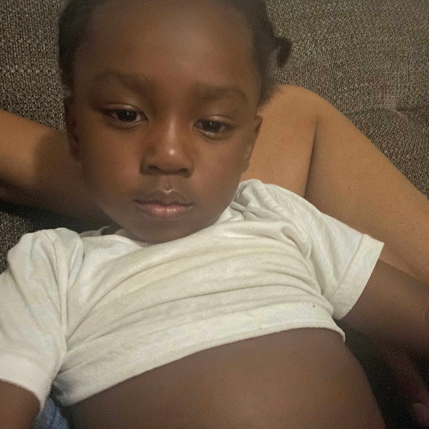 Tyaun is registered to the contest to win money with this photo: brown_background, calm, casual, child, closeup, comfort, couch, expression, face, hair, home, indoor, person, portrait, relaxed, resting, sitting, skin, white_shirt, young_child