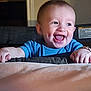 baby, child, smile, happy, indoor, blue_shirt, face, hands, joy, peek, furniture, skin, person, infant, cute, portrait, expression, babywear, toddler, excitement