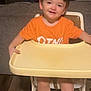Adam joined the competition — help win amazing prizes! child, cute, face, feet, furniture, hair, happy, high_chair, home, indoor, living_room, orange_shirt, person, seat, seated, smiling, table, toddler, wooden_floor, young_child