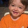 baby, brown_hair, casual_clothing, child, childhood, cute, expression, face, happy, high_chair, home, indoor, messy_shirt, orange_shirt, person, portrait, seated, smiling, toddler, young_child