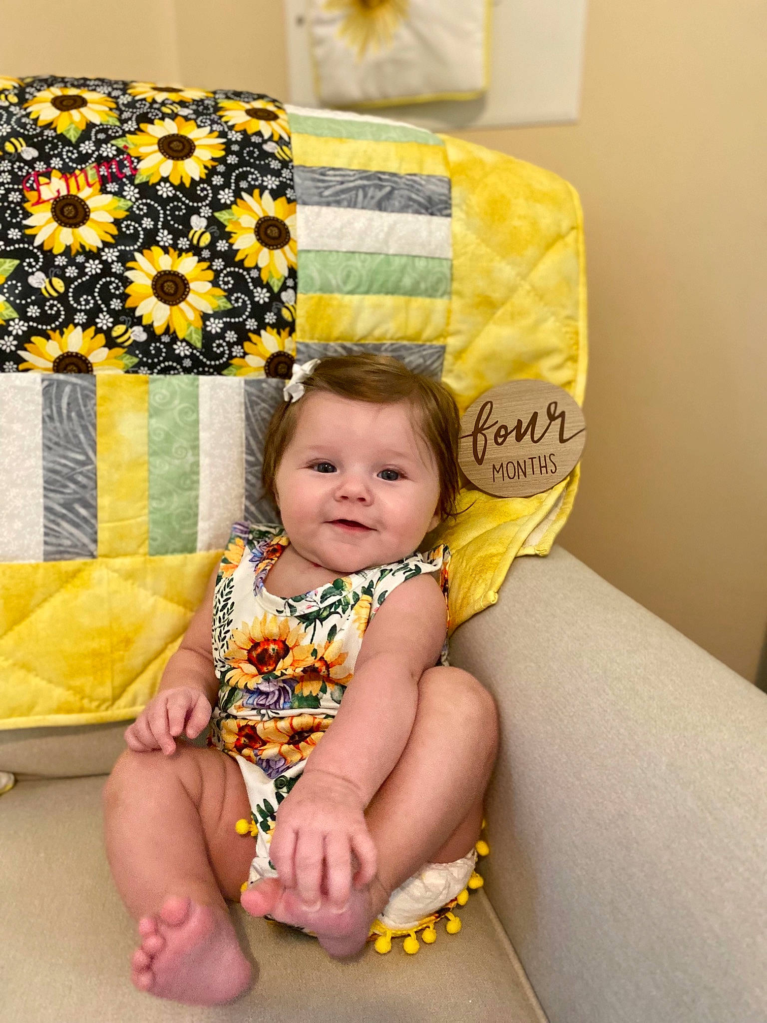 Emmi is registered to the contest to win money with this photo: baby, baby_toddler_clothing, chair, child, comfort, couch, face, foot, fun, happy, human_leg, joy, lap, linens, pattern, person, room, sitting, thigh, throw_pillow