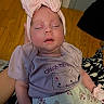 Dasha Umana is registered to the contest to win money with this photo: baby, infant, sleeping, portrait, pink_bow, headband, floral_outfit, shirt, cat_design, clothing, face, closed_eyes, indoors, hardwood_floor, blanket, seated, cozy, cute, photography, child