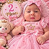 baby, infant, child, girl, portrait, pink, dress, bow, headband, crown, teddy_bear, flowers, blanket, heart_pattern, sitting, lying_down, indoors, birthday, two_months, smiling