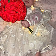 Amélya a rejoint le concours — aidez-le/la à gagner de superbes lots ! baby, infant, face, red_eye, bouquet, red_roses, white_dress, headband, fairy_lights, blanket, bed, sock, hand, portrait, indoor, floral, fabric, cute, newborn, soft_lighting