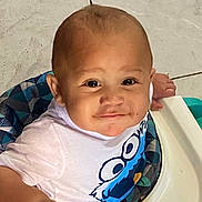 Isaiah is registered to the contest to win money with this photo: baby, infant, child, smiling, portrait, sitting, baby_seat, highchair, cartoon_shirt, clothing, face, eyes, hair, indoor, tiled_floor, home, cute, happy, close_up, photography