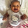 baby, infant, child, smiling, happy, portrait, lying_down, indoors, blanket, bedding, hello_kitty, onesie, pink_clothing, leopard_print, toy, headband, furniture, close_up, joyful, photography