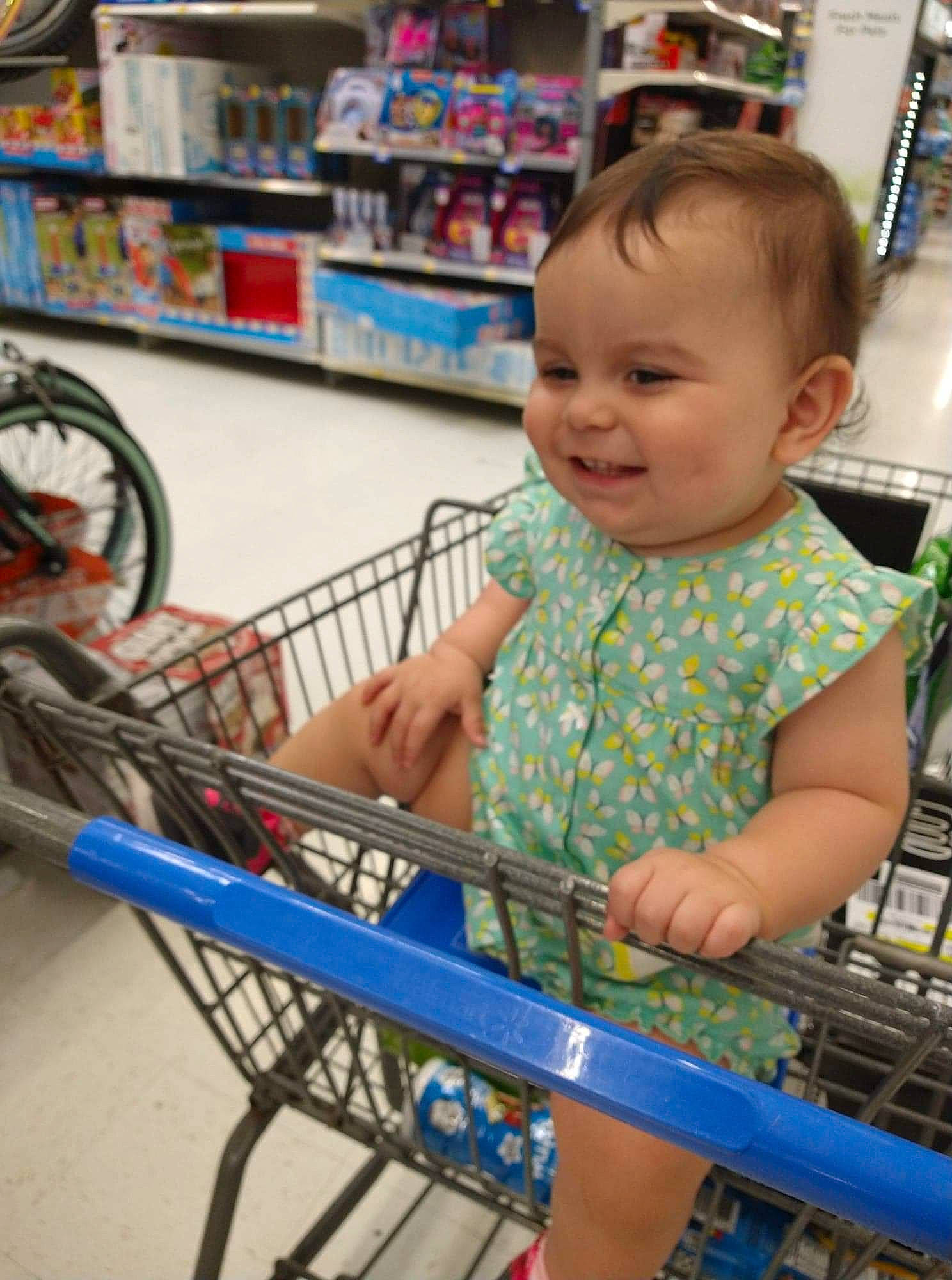 Fallon is registered to the contest to win money with this photo: baby, baby_toddler_clothing, blue, cart, child, customer, engineering, fun, joy, leisure, person, photograph, product, retail, shelf, shopping, shopping_cart, smile, tire, toddler
