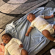Jamiah joined the competition — help win amazing prizes! baby, blanket, carpet, child, clothing, floor, infant, laying, living_room, pattern, person, playtime, portrait, resting, socks, two_children, white_clothing, young_child, indoor, cute