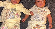 Jamiah joined the competition — help win amazing prizes! baby, babies, child, infant, carpet, clothing, yellow_outfit, winnie_the_pooh, toddler, cute, lying_down, paired, matching_clothes, socks, indoors, floor, two_children, portrait, happy, casual