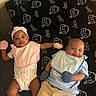 Jamiah is registered to the contest to win money with this photo: baby, infant, toddler, blanket, mittens, headband, bib, clothing, floor, wooden_floor, pattern, nap, zzz, cute, lying_down, smiling, two_babies, indoor, child, portrait