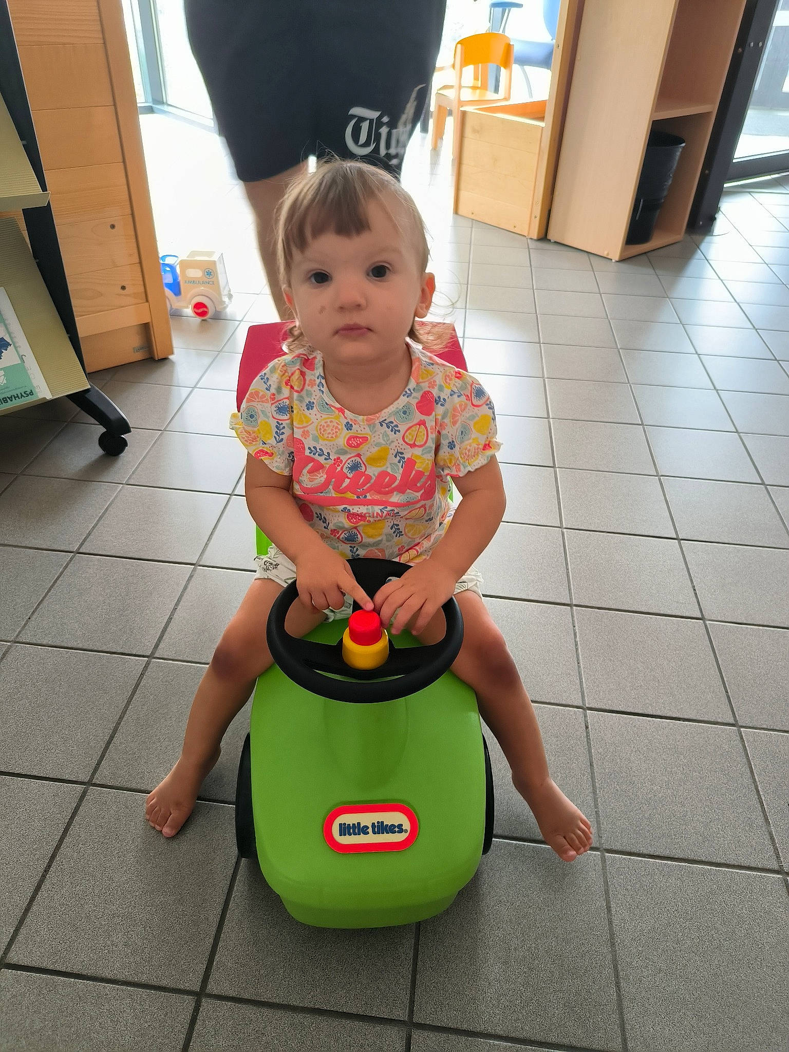 Stella participe au concours pour gagner de l'argent avec cette photo : baby, baby_toddler_clothing, bean_bag_chair, cabinetry, child, cleanliness, floor, flooring, fun, happy, hardwood, human_leg, knee, leisure, person, play, sitting, t_shirt, thigh, toddler