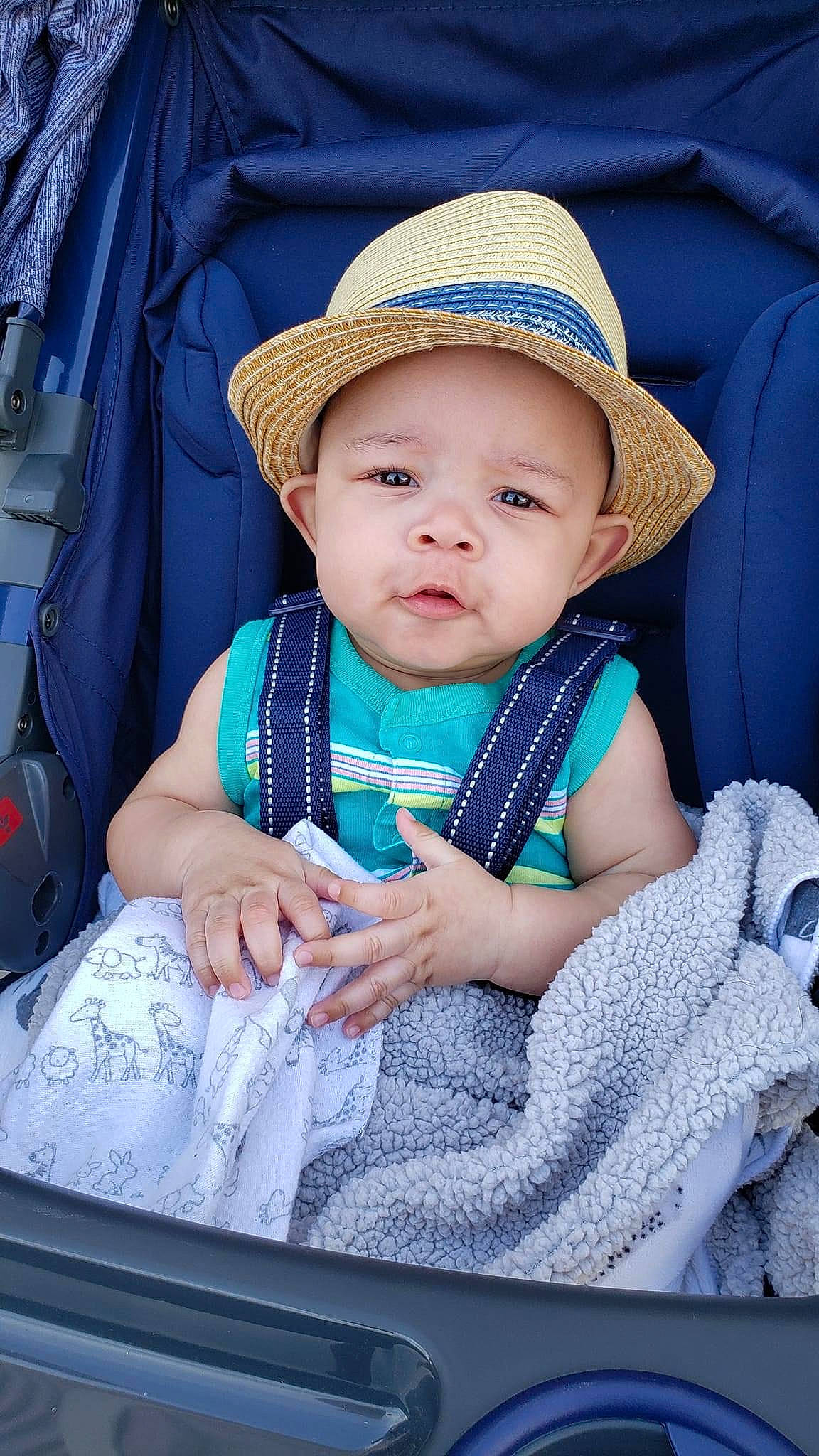 Prince is registered to the contest to win money with this photo: azure, baby, baby_carriage, baby_products, baby_toddler_clothing, blue, cheek, child, comfort, electric_blue, facial_expression, fashion_accessory, happy, hat, headwear, pattern, person, photograph, sitting, skin