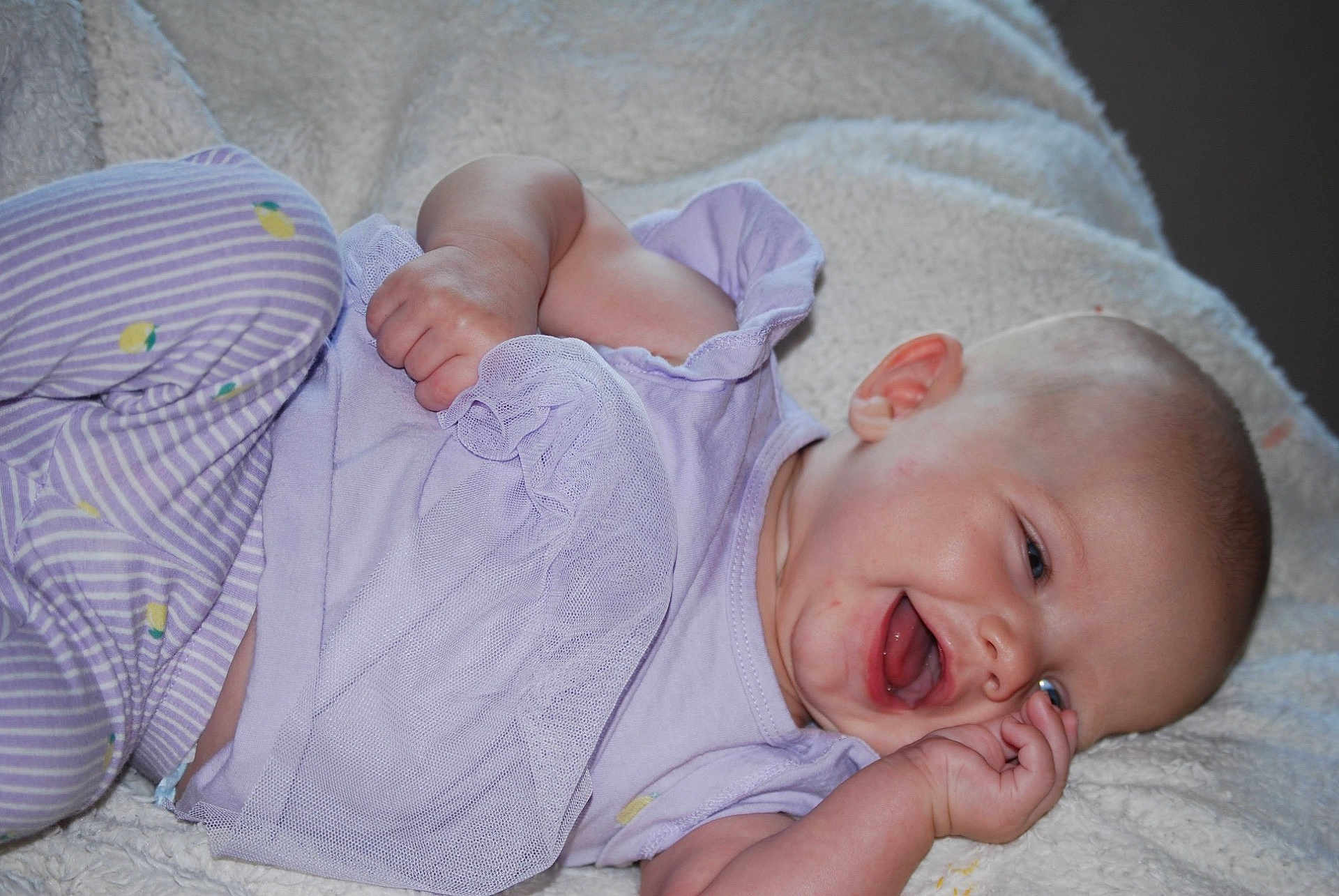 Everleigh Janis Mae is registered to the contest to win money with this photo: baby, infant, smiling, happy, clothing, purple, blanket, lying_down, cute, face, child, skin, hand, head, cheeks, small_fingers, toddler, young_child, indoors, soft_texture
