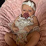 baby, infant, pacifier, headband, flower, blanket, pink, clothing, cute, lying_down, skin, human, child, toddler, relaxing, indoors, soft_texture, comfort, small_hands, small_feet