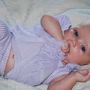 Everleigh Janis Mae joined the competition — help win amazing prizes! baby, blanket, blue_eyes, child, clothing, comfort, cute, face, hand, indoors, infant, lying_down, newborn, portrait, purple, skin, sleepwear, soft_texture, striped_pants, young