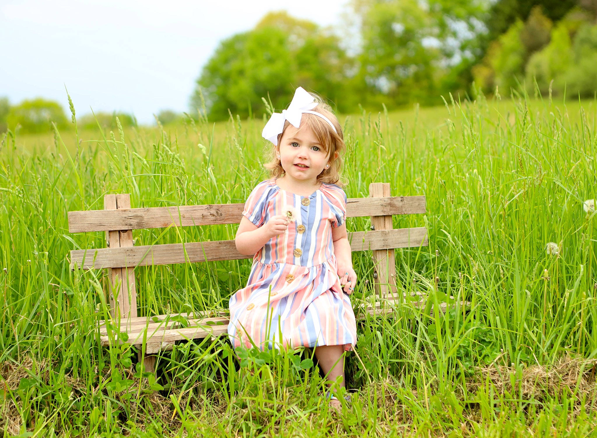 Gracie is registered to the contest to win money with this photo: baby_toddler_clothing, child, clothing, fun, grass, grass_family, grassland, happy, joy, landscape, leisure, meadow, natural_landscape, people_in_nature, person, plant, sky, smile, summer, sunlight