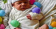 Silas is registered to the contest to win money with this photo: baby, basket, blanket, booties, colorful, cozy, cute, easter_eggs, hand, indoors, infant, knitted, newborn, peaceful, resting, sleeping, small, soft, white_hat, wrapped