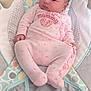 baby, infant, onesie, pink_clothing, baby_rocker, plush_toy, soft_toy, flooring, patterned_fabric, child, cute, sleepwear, comfort, indoor, newborn, infant_fashion, seated, portrait, baby_girl, relaxed