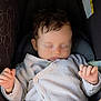 baby, sleeping, infant, car_seat, knit_cardigan, cozy, hands, face, closed_eyes, hair, child, cute, peaceful, soft_light, indoor, portrait, newborn, relaxing, comfort, small_fingers