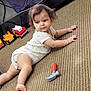 Evangeline is registered to the contest to win money with this photo: baby, child, carpet, toy, toy_hammer, toy_trucks, onesie, floor, indoor, person, infant, crawling, cute, playtime, carpet_texture, furniture, head, limbs, expression, home