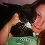 Freck is registered to the contest to win money with this photo: woman, cat, black_cat, white_whiskers, indoor, cuddle, close_up, casual, green_shirt, portrait, human_face, pet, animal, cozy, affection, long_hair, hand, whiskers, relaxed, intimate