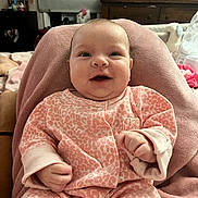 Amara is registered to the contest to win money with this photo: baby, blanket, child, couch, cozy, cute, face, furniture, hands, happy, indoor, infant, person, pink_pajamas, portrait, room, seated, smiling, soft_texture, young_child