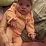 Amara is registered to the contest to win money with this photo: baby, blanket, bow, child, cozy, cushion, cute, hand, headband, indoor, infant, newborn, orange_outfit, person, pillow, portrait, resting, sleepwear, soft_texture, warm