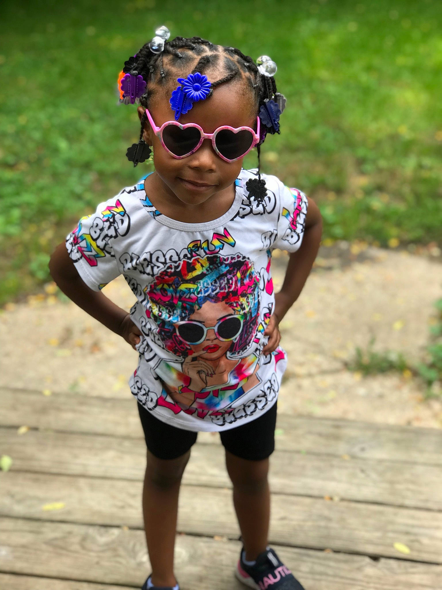Saniah is registered to the contest to win money with this photo: baby_toddler_clothing, cool, dress, eyewear, glasses, goggles, grass, happy, head, headgear, leisure, person, personal_protective_equipment, pink, plant, sleeve, sunglasses, t_shirt, toddler, tree
