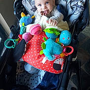 Ethan joined the competition — help win amazing prizes! baby, child, stroller, infant, tongue_out, smiling, blue_eyes, portrait, toys, stuffed_animal, plush_toy, colorful, blanket, red, polka_dots, indoor, sitting, playtime, happy, baby_gear