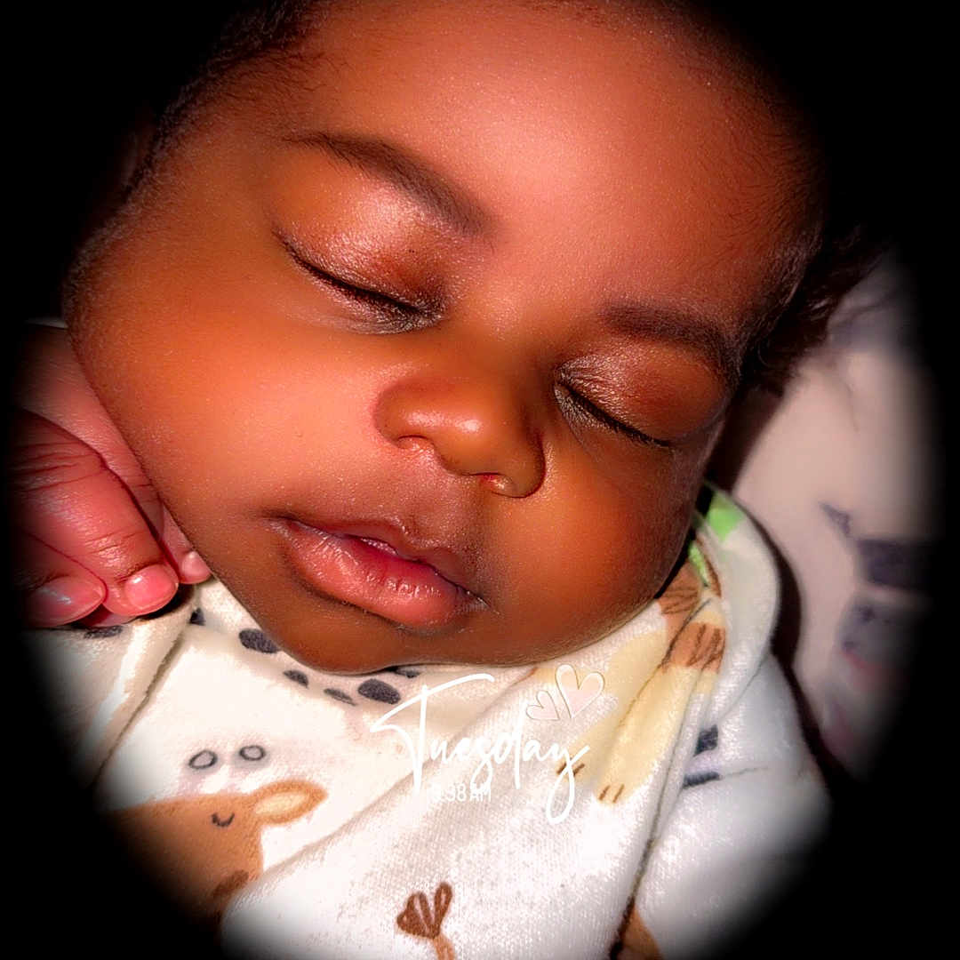 Prince is registered to the contest to win money with this photo: accessories, baby, bodypart, bonnet, clothing, ear, earring, face, finger, hand, head, jewelry, mouth, newborn, person, photography, portrait, quilt, reading, sleeping
