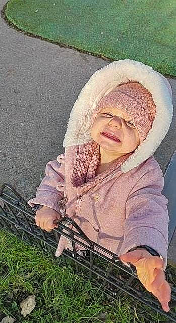 Mya participe au concours pour gagner de l'argent avec cette photo : asphalt, baby, baby_carriage, baby_products, baby_toddler_clothing, child, comfort, facial_expression, fun, grass, headwear, outerwear, pattern, people_in_nature, person, photograph, plant, road_surface, sitting, skin