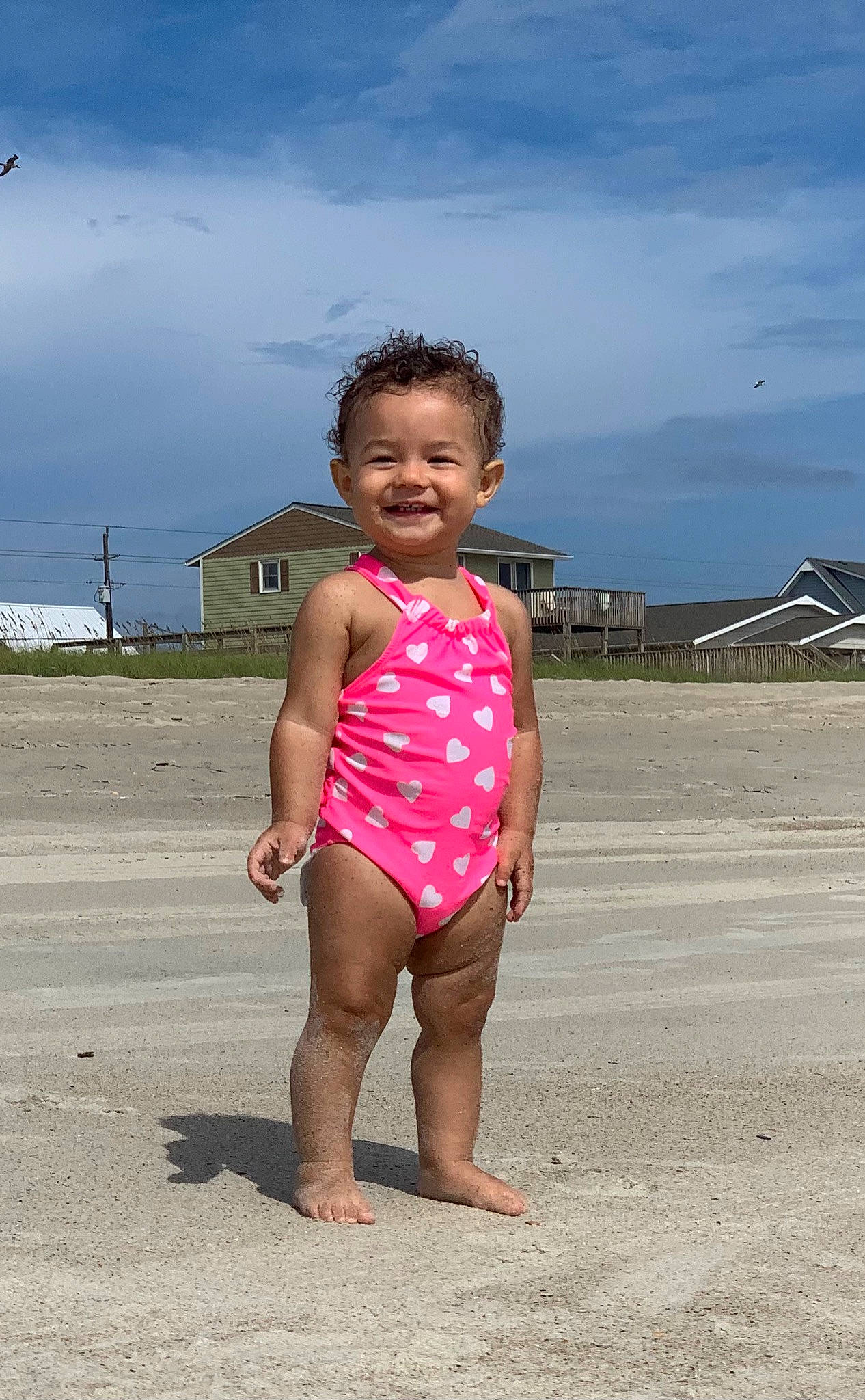 Emerson is registered to the contest to win money with this photo: barefoot, beach, child, fun, joy, person, pink, sand, sea, smile, summer, toddler, vacation