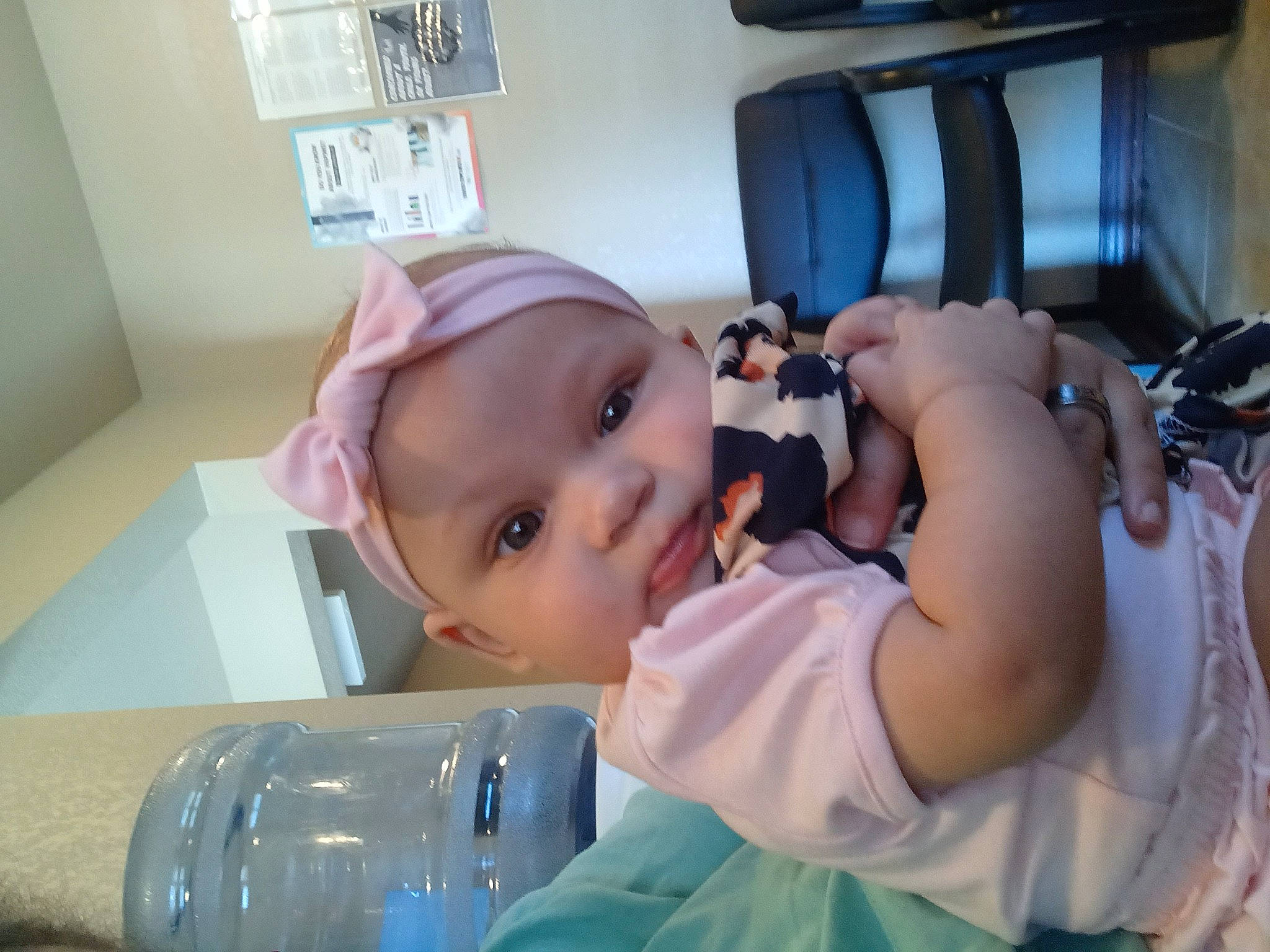 Sabrina is registered to the contest to win money with this photo: baby, baby_products, baby_toddler_clothing, bottle, chair, cheek, child, comfort, drinking_water, drinkware, fun, hat, headwear, person, plastic_bottle, room, skin, smile, toddler, water