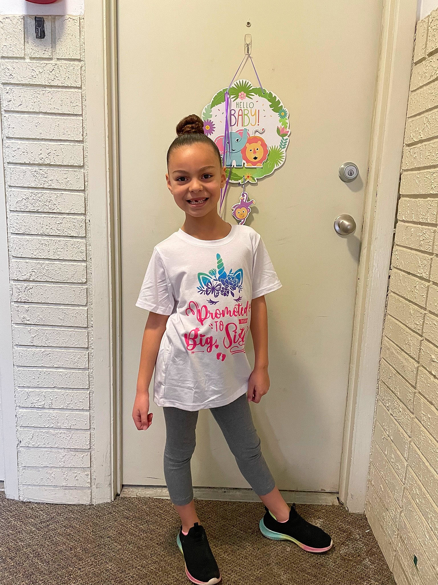 Mileena is registered to the contest to win money with this photo: child, door, face, fashion_design, hair, happy, joy, leg, magenta, pattern, person, pink, sandal, shoe, sleeve, smile, standing, street_fashion, t_shirt, toddler