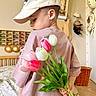 bed, bedroom, bouquet, boy, cap, casual_clothing, child, flowers, hat, holding_flowers, indoor, nursery, pastel_colors, shelf, side_profile, toddler, toy_cars, tulips, wicker_basket, wooden_furniture