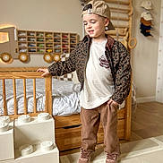 Noah participe au concours pour gagner de l'argent avec cette photo : baseball_cap, bed, boy, cap, child, crib, jacket, leopard_jacket, pants, playroom, room_decor, shelf, smile, sneakers, standing, toddler, toy_bricks, toy_cars, tshirt, wooden_furniture