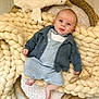 baby, basket, blanket, blue_outfit, cardigan, child, clothing, cozy, face, floor, footwear, furniture, hand, head, indoor, knit_blanket, plush_toy, rattle, smiling, toy