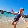 Emy participe au concours pour gagner de l'argent avec cette photo : child, beach, swimsuit, sand, water, ocean, sky, sunny, hat, playful, summer, vacation, holiday, person, shore, rock, wave, fun, outdoor, barefoot