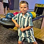 Ayden a rejoint le concours — aidez-le/la à gagner de superbes lots ! child, boy, bowling_alley, bowling_balls, striped_clothing, shorts, shirt, sneakers, carpet, floor, indoor, person, pose, confident, recreation, game, fun, leisure, adult, background