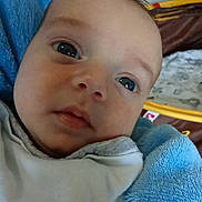 Jordan participe au concours pour gagner de l'argent avec cette photo : baby, bedding, blanket, blue_towel, cheeks, close_up, cuddly, cute, eyes, face, gaze, head, indoor, infant, mouth, nose, portrait, skin, soft_texture, young_child