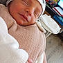 Jordan participe au concours pour gagner de l'argent avec cette photo : baby, bedroom, blanket, closeup, clothing, cozy, furniture, hand, hat, indoor, monitor, newborn, paper_towel, peaceful, person, relaxation, sleeping, soft, table, wood_floor