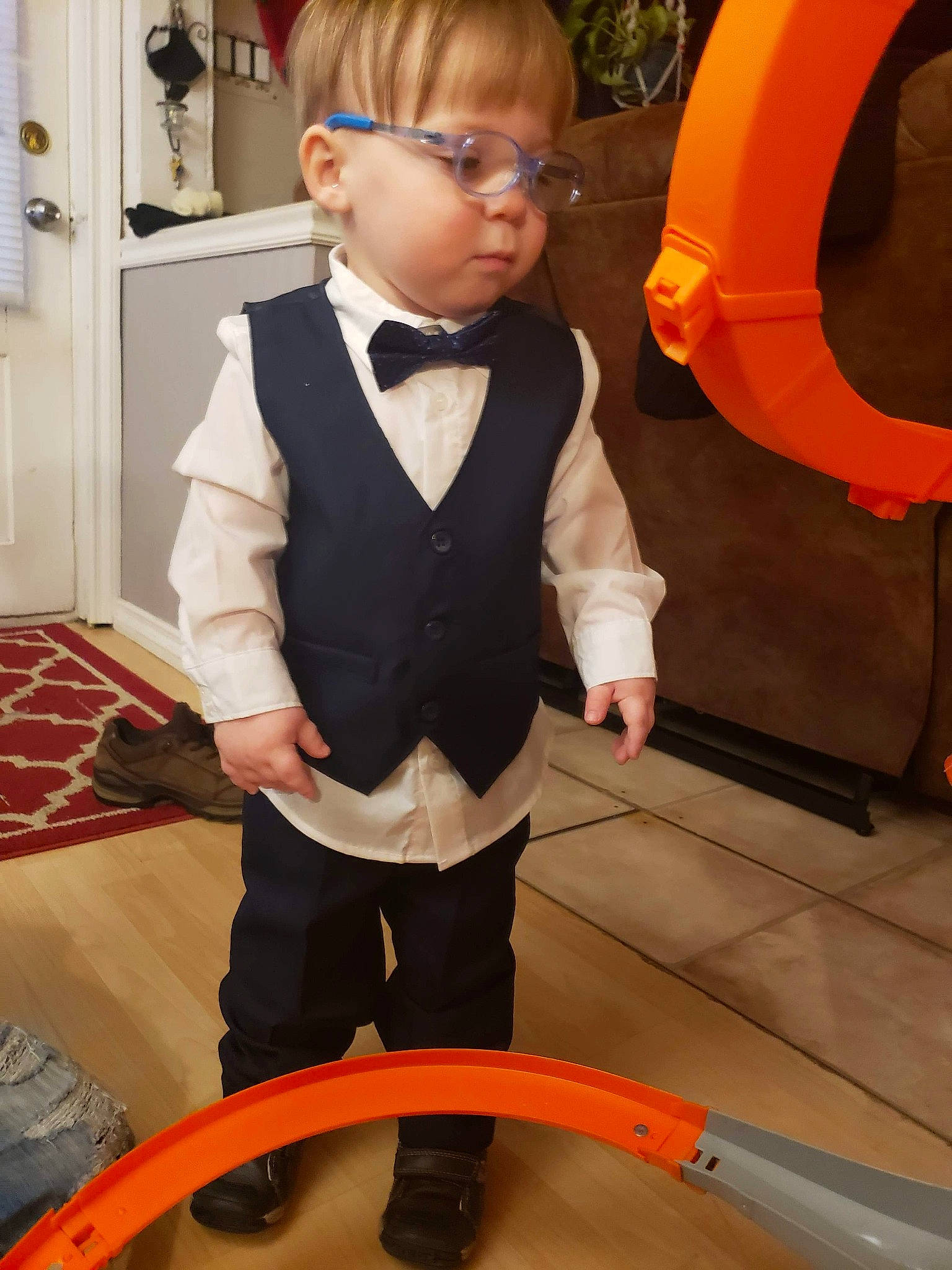 Jacob a rejoint le concours — aidez-le/la à gagner de superbes lots ! baby_toddler_clothing, blazer, bow_tie, child, collar, door, dress_shirt, floor, flooring, formal_wear, fun, orange, person, room, sitting, sleeve, suit, tie, toddler, uniform