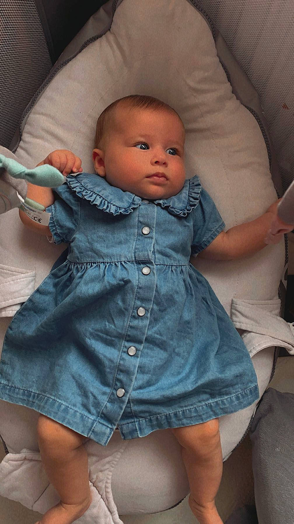 Chiara participe au concours pour gagner de l'argent avec cette photo : abdomen, baby, baby_toddler_clothing, button, cheek, child, comfort, finger, iris, lip, mouth, nose, organ, person, sitting, skin, sleeve, thigh, toddler, trunk