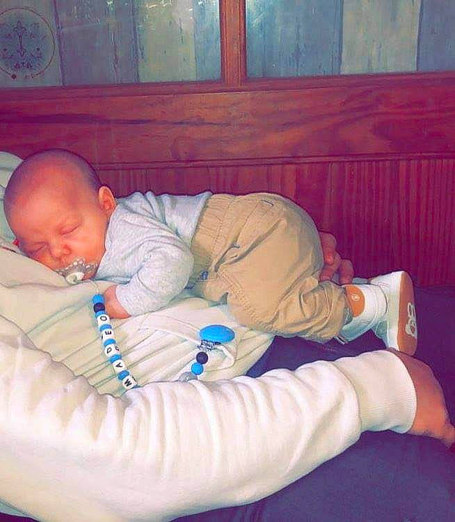 Amadéo participe au concours pour gagner de l'argent avec cette photo : arm, baby, baby_products, baby_sleeping, baby_toddler_clothing, bedtime, child, comfort, fun, human_body, human_leg, knee, lap, linens, person, room, sitting, sock, thigh, toddler