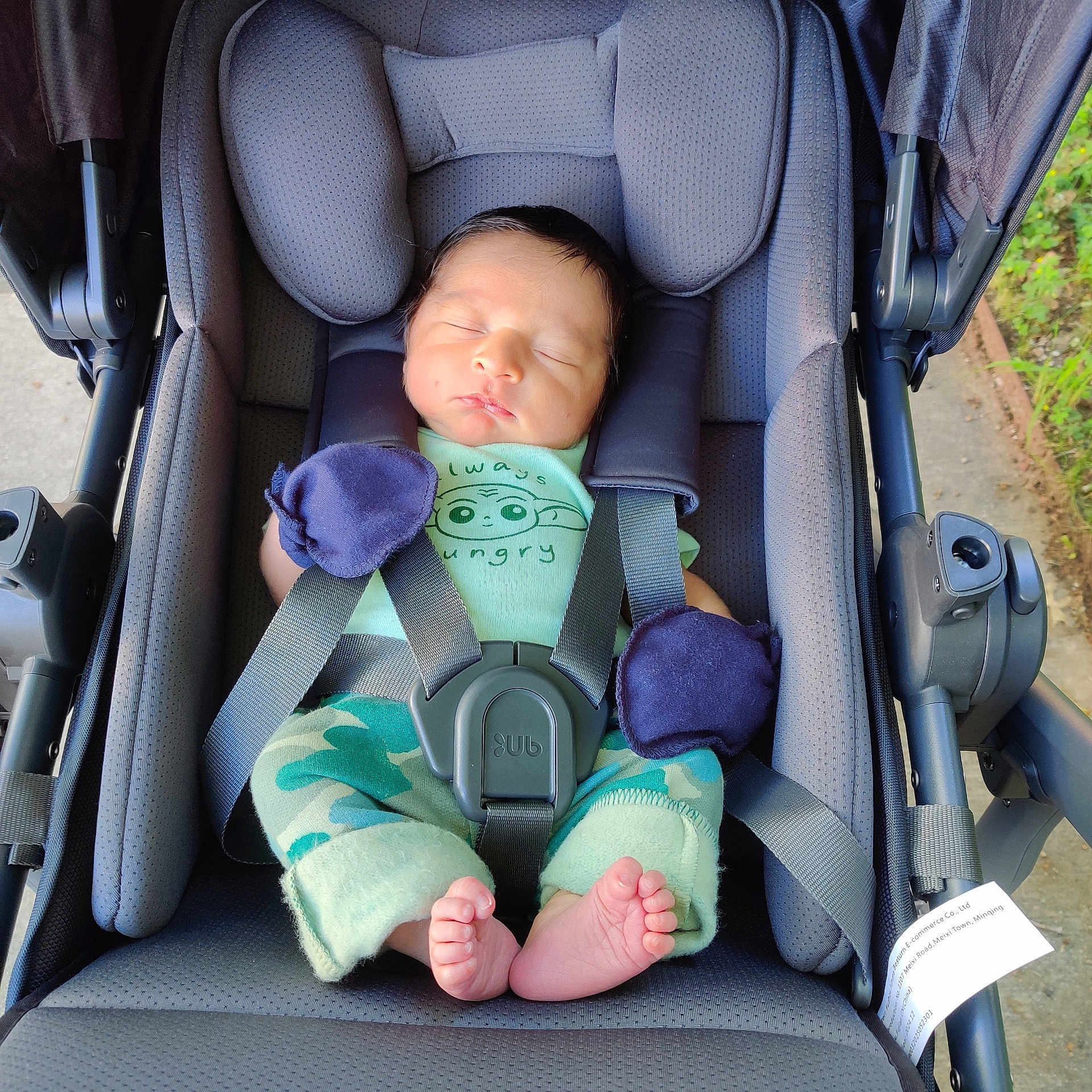 Rafael is registered to the contest to win money with this photo: baby, newborn, stroller, sleeping, mittens, infant, child, seatbelt, cushion, foot, clothing, outdoor, person, portrait, baby_clothes, camouflage, headrest, rest, peaceful, baby_feet